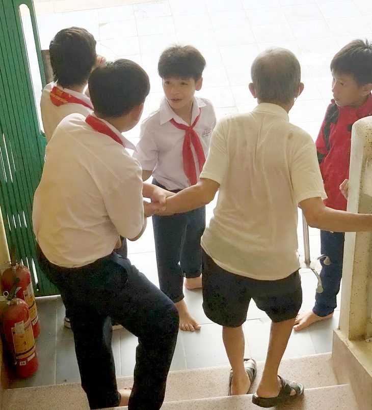 Các bạn nhỏ dìu cụ ông xuống cầu thang - Ảnh: Tác giả cung cấp Các bạn nhỏ dìu cụ ông xuống cầu thang - Ảnh: Tác giả cung cấp